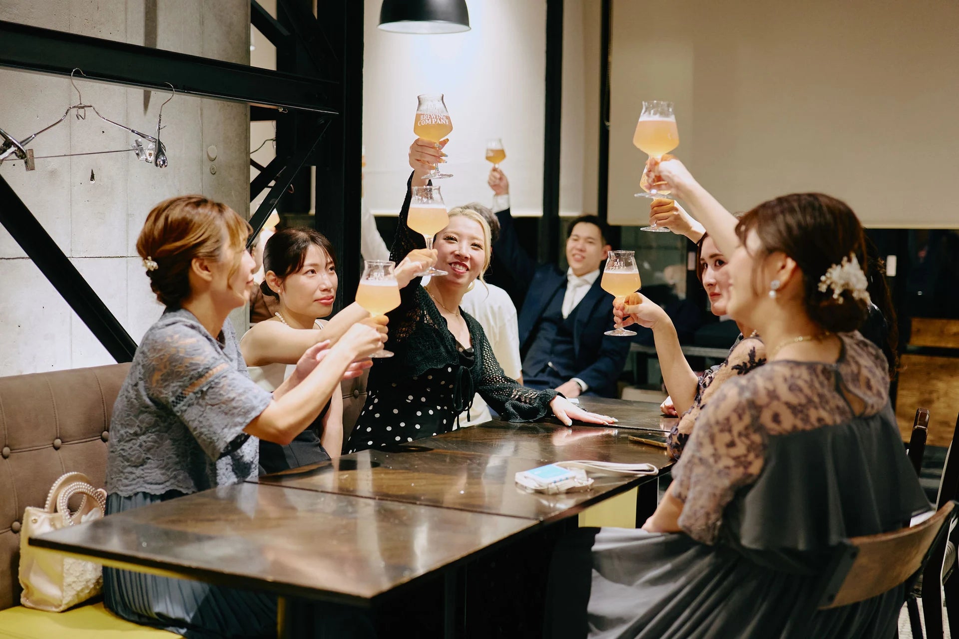 Far Yeast Tokyoでクラフトビールのグラスを掲げて乾杯するグループ